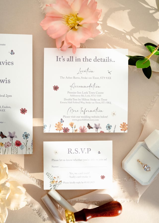 Wildflower details card and RSVP card with watercolour meadow borders, styled with a peach flower, a ring box and a wax seal stamp.